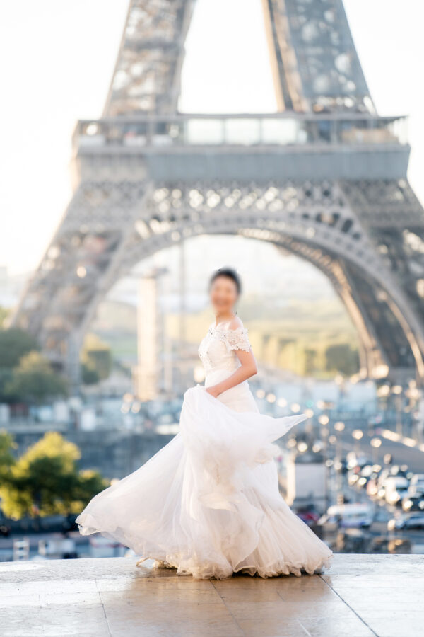 エッフェル塔を背景に写真を撮られている花嫁